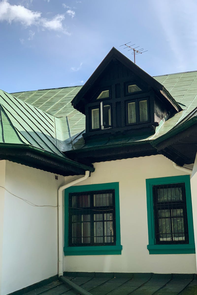 Charming Romanian house with green roof and dormer window in Sinaia.
